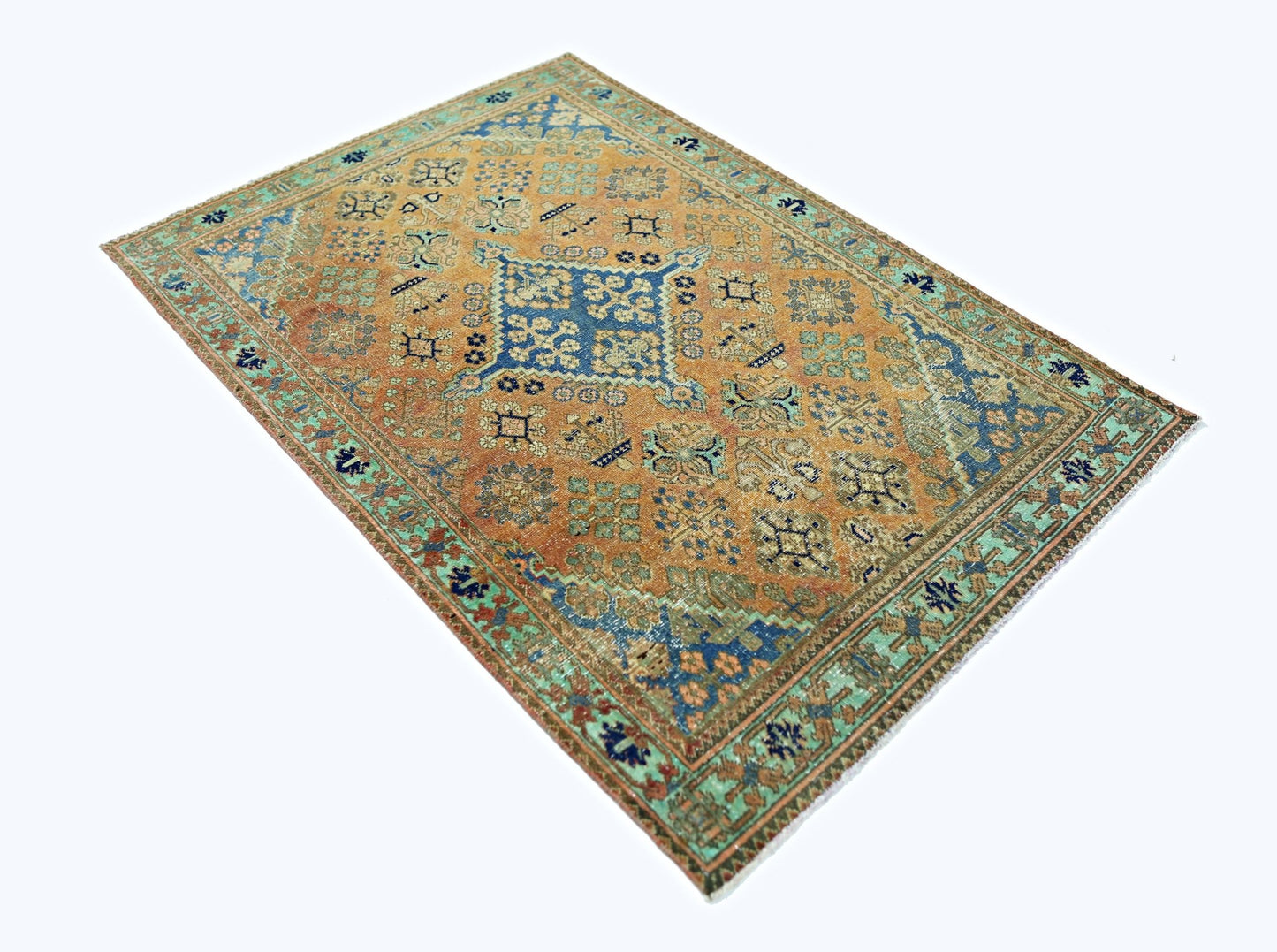 A rectangular vintage Persian rug featuring a central blue medallion on an orange field.