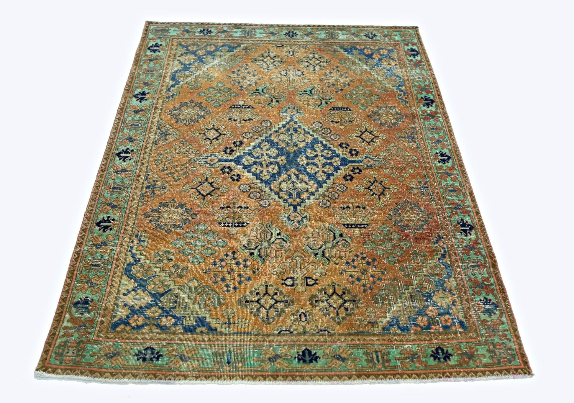 A rectangular vintage Persian rug featuring a central blue medallion on an orange field.