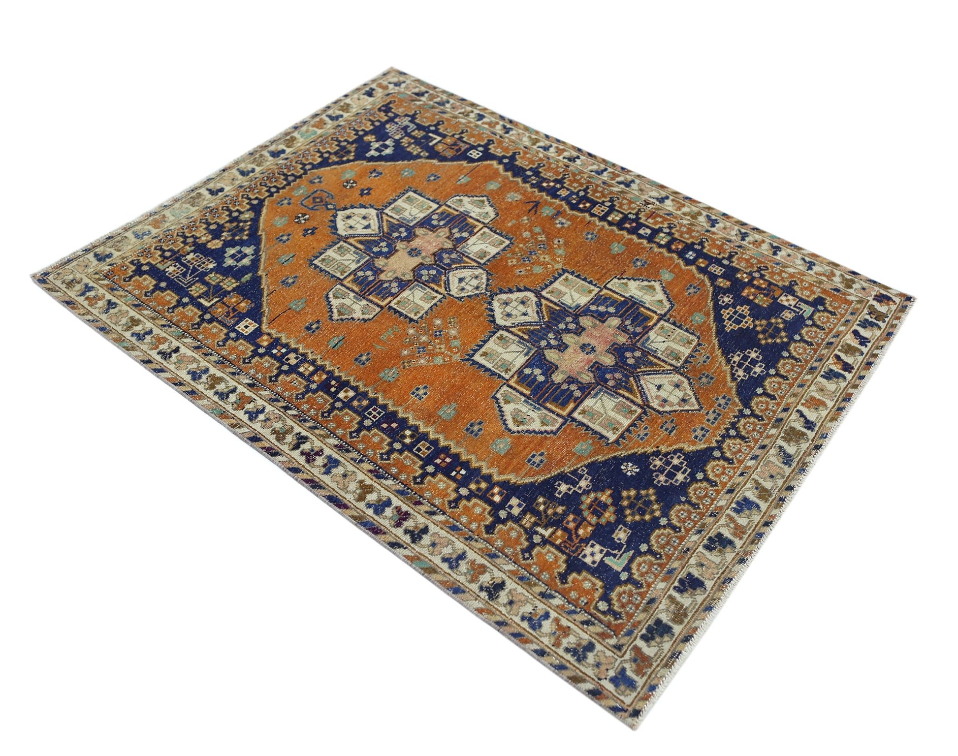 A vintage Persian rug featuring a geometric medallion pattern in orange and blue tones.