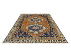 A vintage Persian rug featuring a central geometric medallion in orange and blue tones.