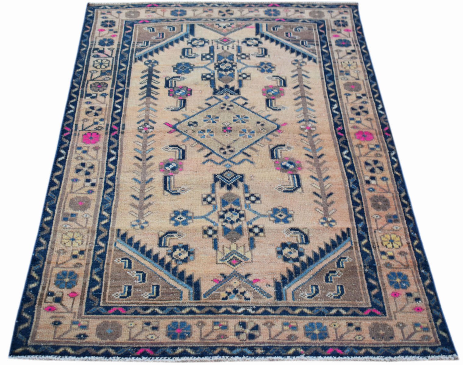 A handwoven vintage Persian rug featuring a geometric pattern in blue, pink, and tan tones.