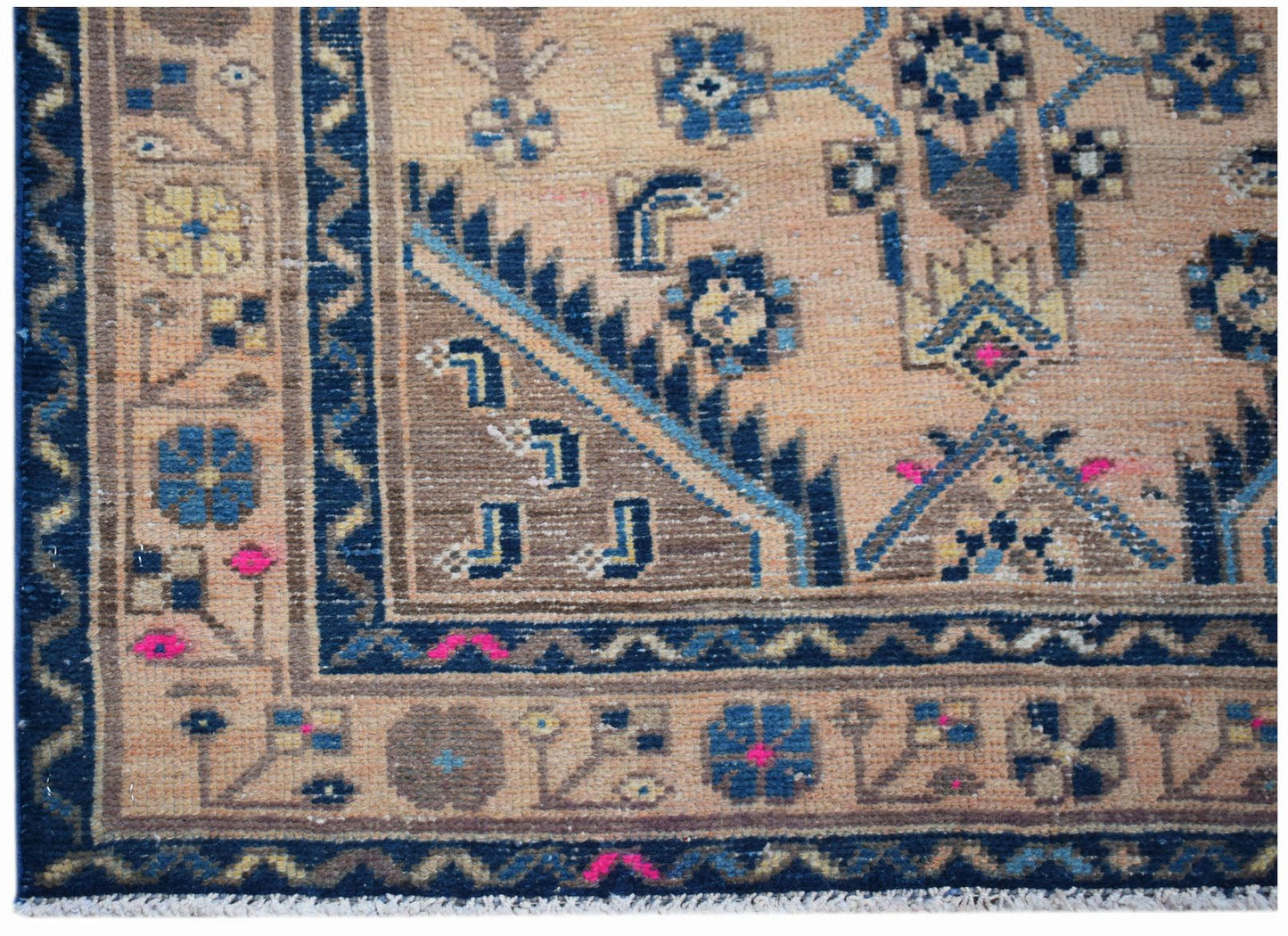 A handwoven vintage Persian rug featuring a geometric floral pattern in blue and tan tones.