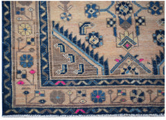 A handwoven vintage Persian rug featuring a geometric floral pattern in blue and tan tones.