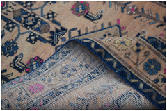 A vintage handwoven Persian rug with a worn, patterned design in shades of blue, pink, and tan.