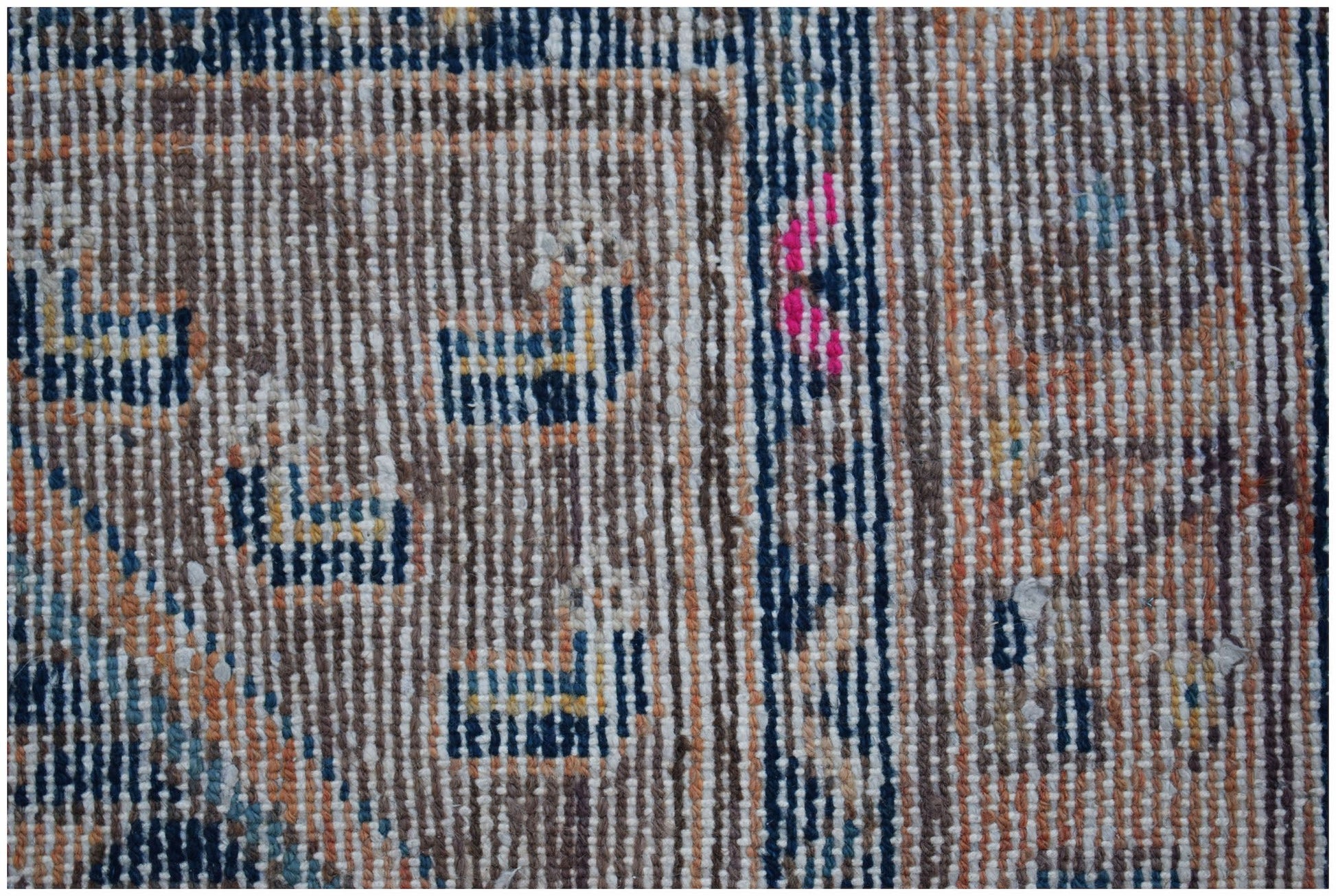 A close-up of a vintage Persian rug featuring geometric patterns in blue, orange, and white wool.