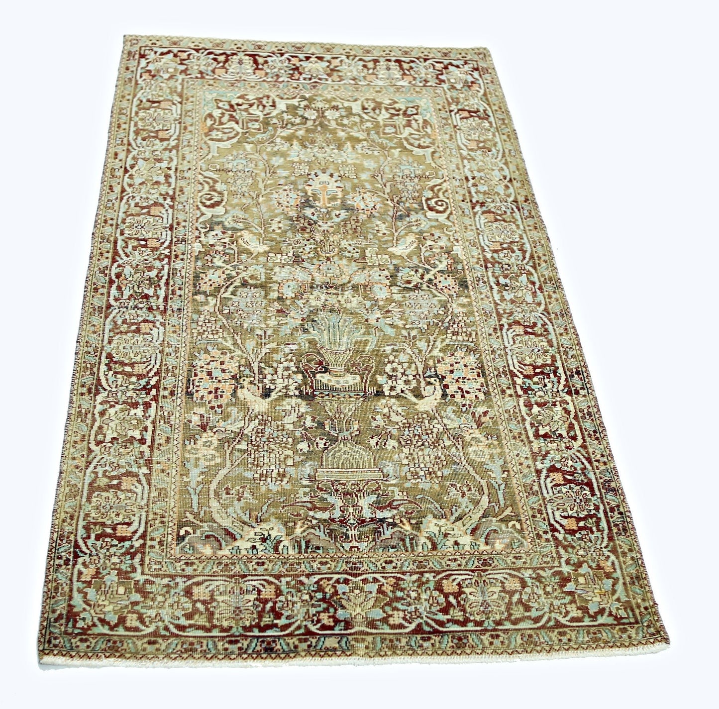 A vintage handmade Persian rug featuring intricate floral patterns in muted earth tones.