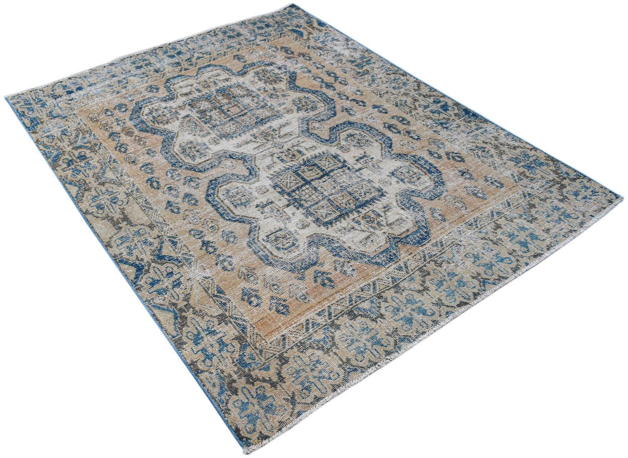 A vintage Persian rug featuring a blue and tan geometric pattern on a distressed wool pile.