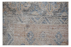 A handwoven vintage Persian rug featuring a distressed pattern in blue, brown, and cream tones.