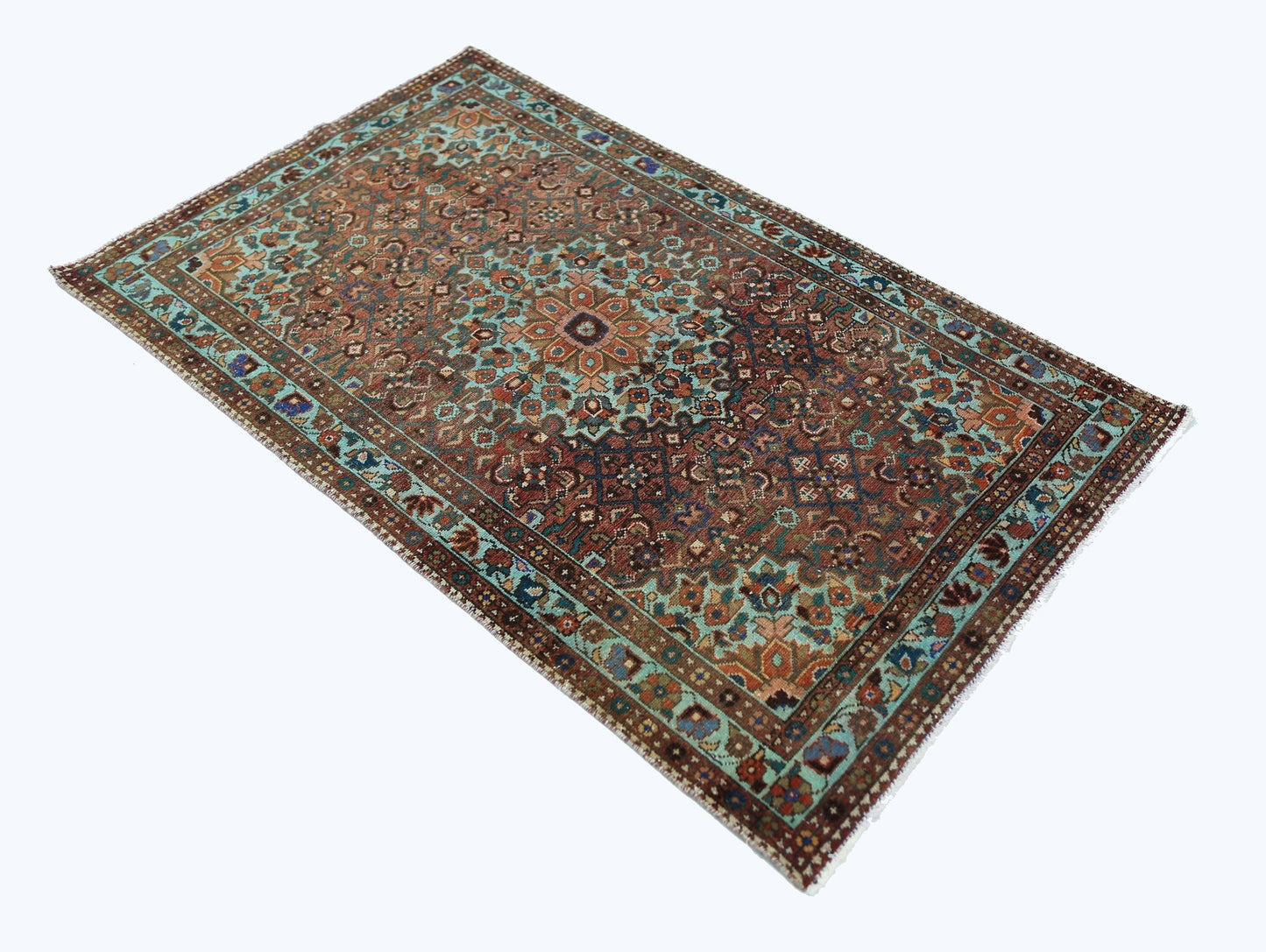 A rectangular vintage Persian rug featuring an intricate floral pattern in blue and brown tones.
