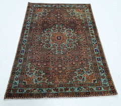 A rectangular vintage Persian rug featuring a central floral medallion in shades of red and teal.