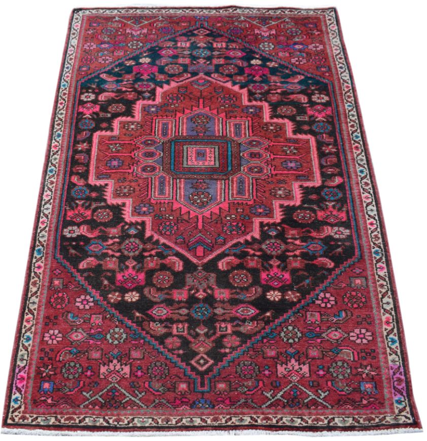 A rectangular handmade Persian wool rug featuring a geometric medallion in red, black, and blue.