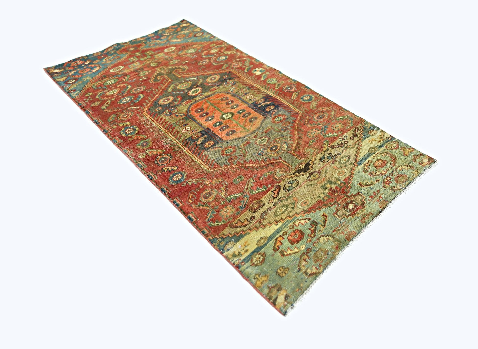 A rectangular vintage Persian rug featuring intricate geometric patterns in red, green, and blue.