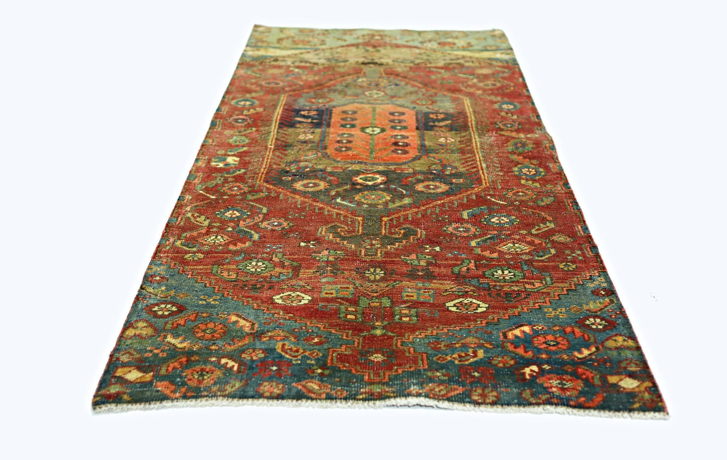 A vintage handmade Persian rug featuring a central medallion on a red field with blue accents.