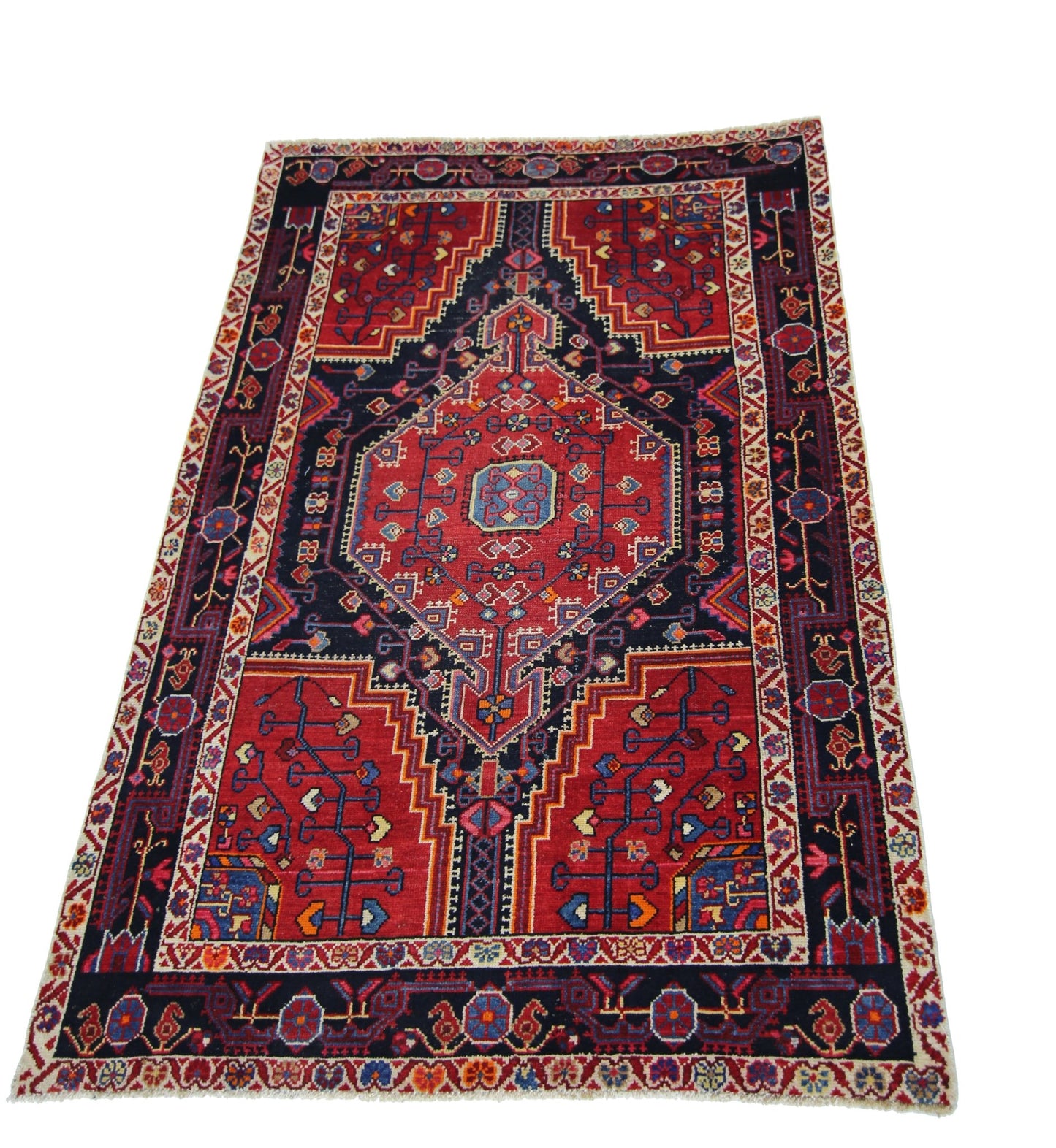 A rectangular vintage Persian rug featuring a geometric red and navy blue medallion pattern.