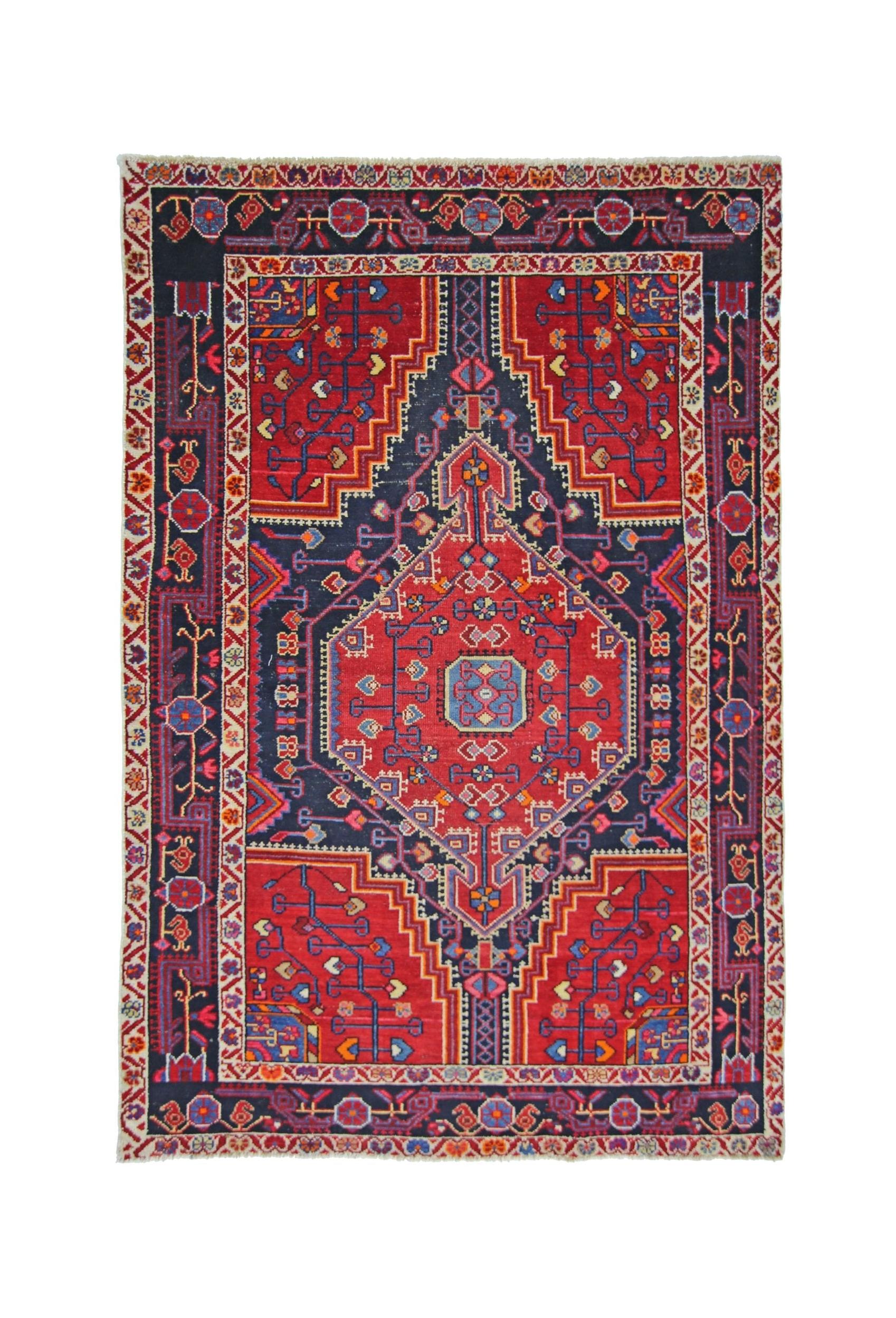 A handmade vintage Persian rug featuring a geometric diamond medallion in red and navy blue.