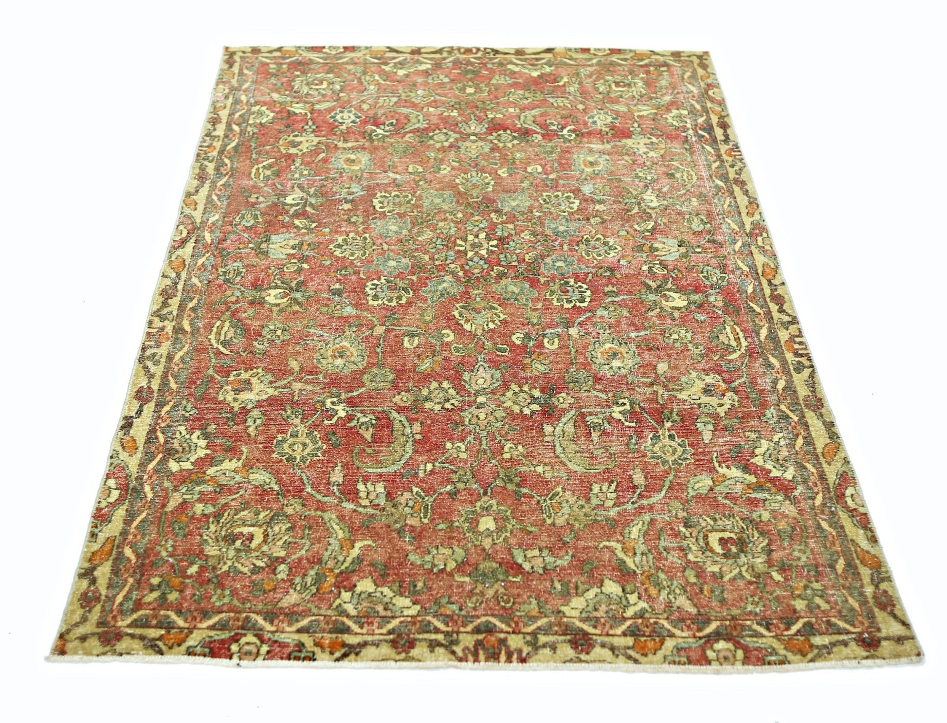 A vintage handmade Persian rug featuring a floral pattern in shades of red, green, and beige.