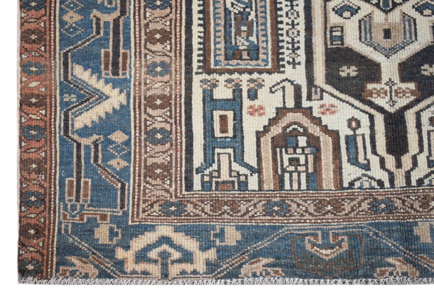 A handwoven vintage Persian rug featuring intricate geometric patterns in blue, brown, and cream.