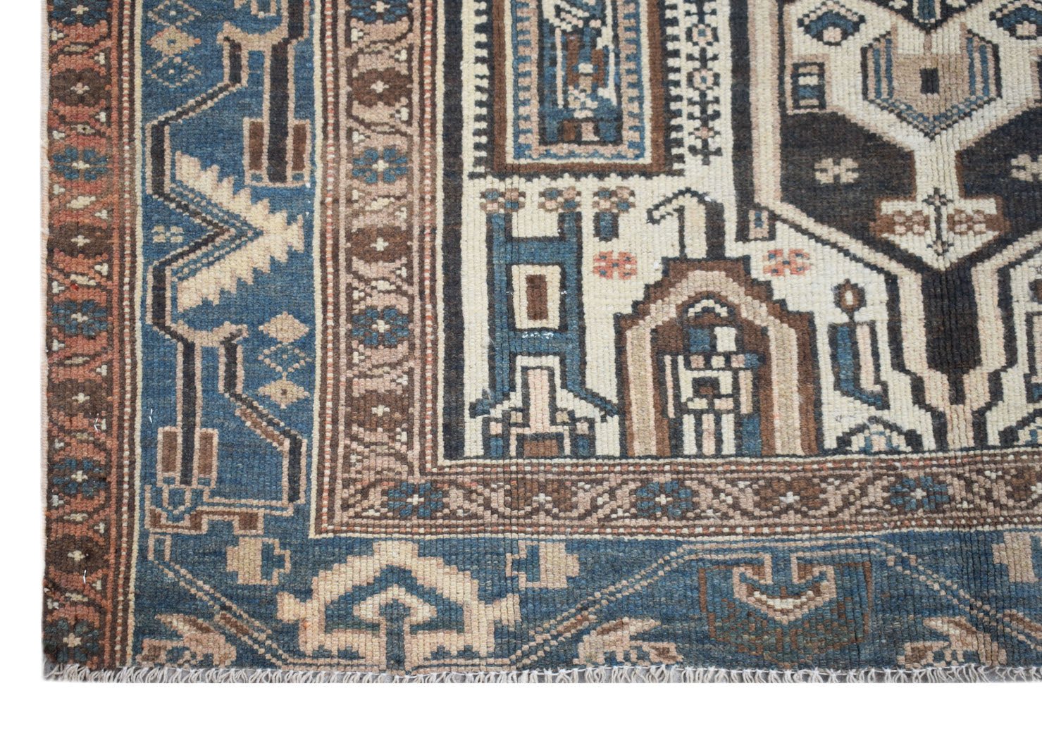 A handwoven vintage Persian rug featuring intricate geometric patterns in blue, brown, and cream.