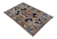 A handwoven vintage Persian rug featuring a geometric pattern in shades of blue, tan, and orange.