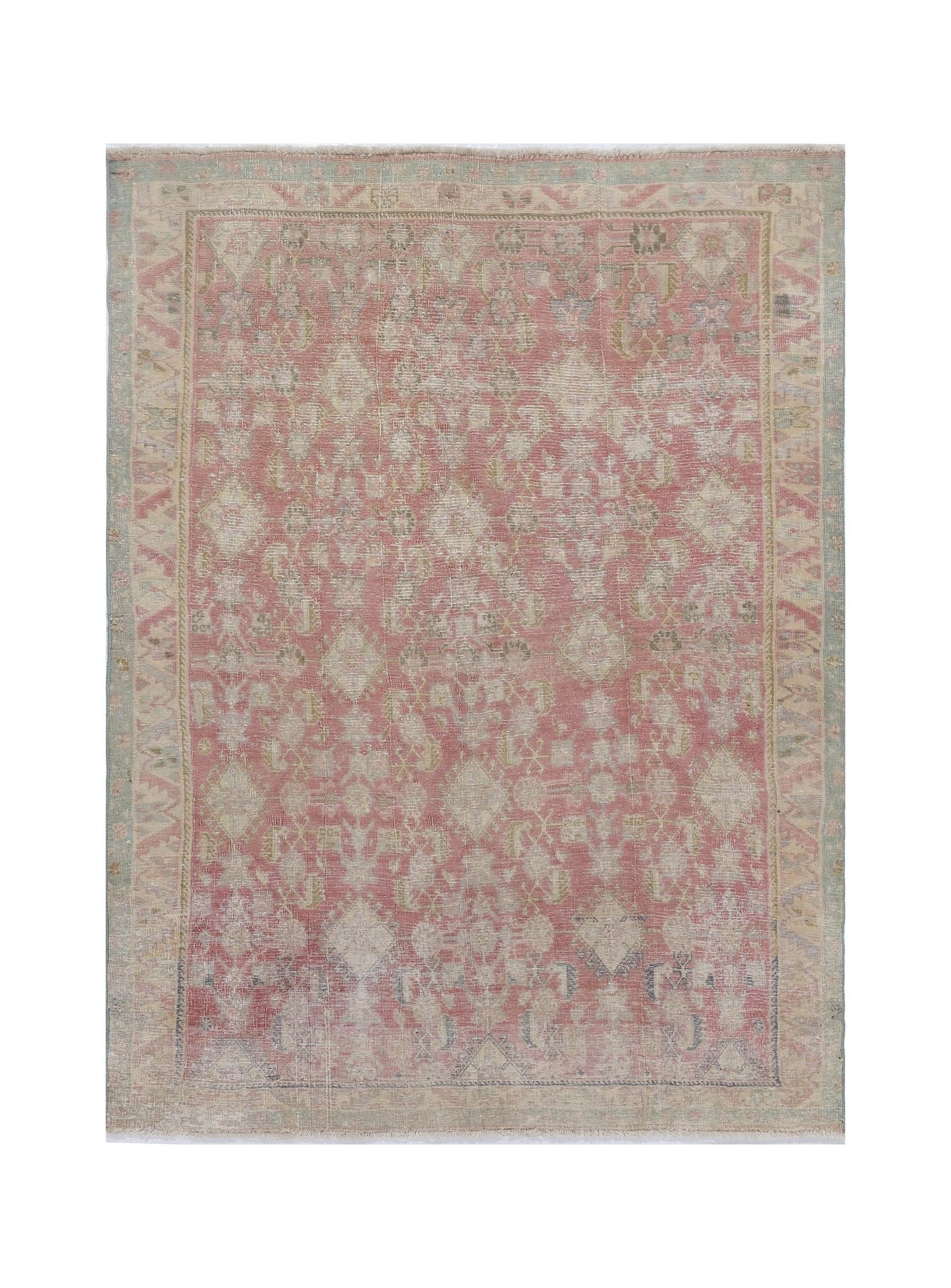 A vintage handmade Persian rug featuring a faded pink and cream geometric floral pattern.