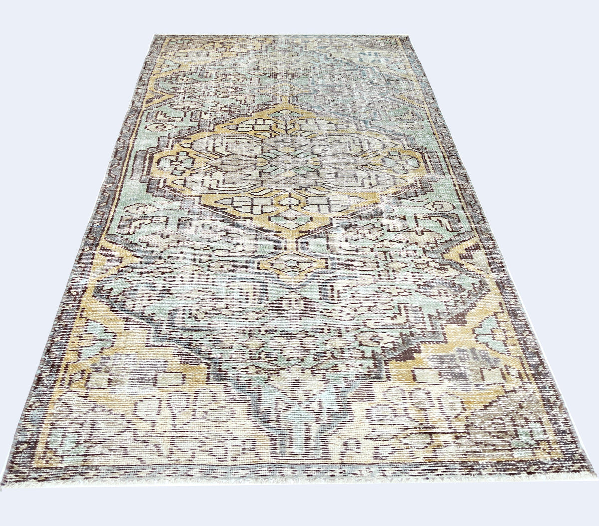 A vintage Persian rug featuring a distressed geometric pattern in shades of yellow, blue, and brown.
