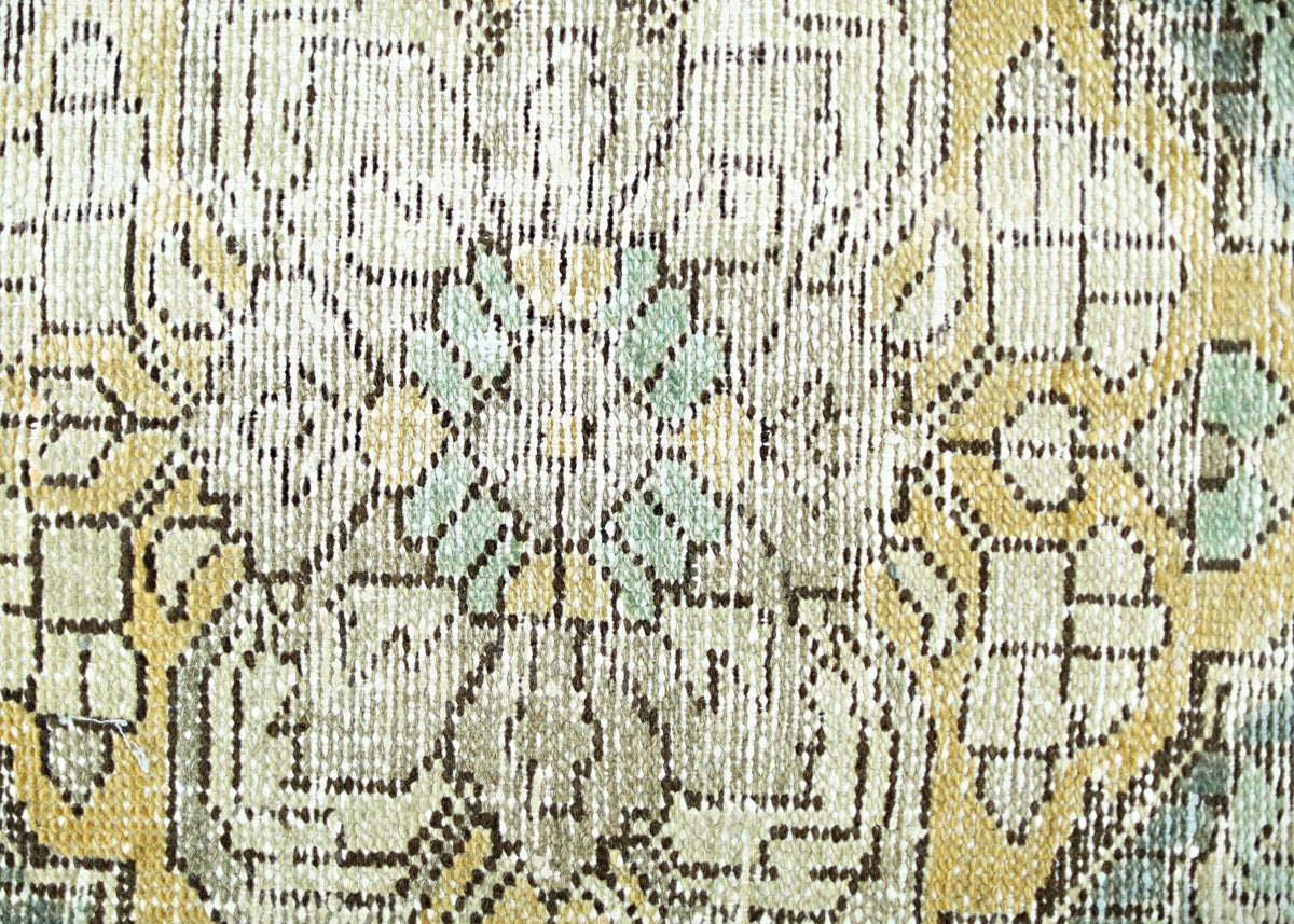 A close-up view of a vintage Persian rug featuring intricate floral patterns in muted tones.