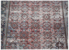A vintage handwoven Persian rug featuring a detailed geometric pattern in red, blue, and cream.