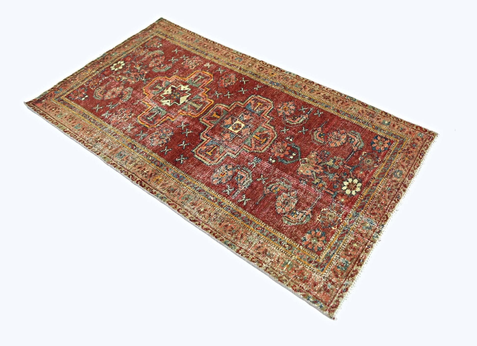 A rectangular vintage Persian rug featuring a red field with intricate geometric patterns.
