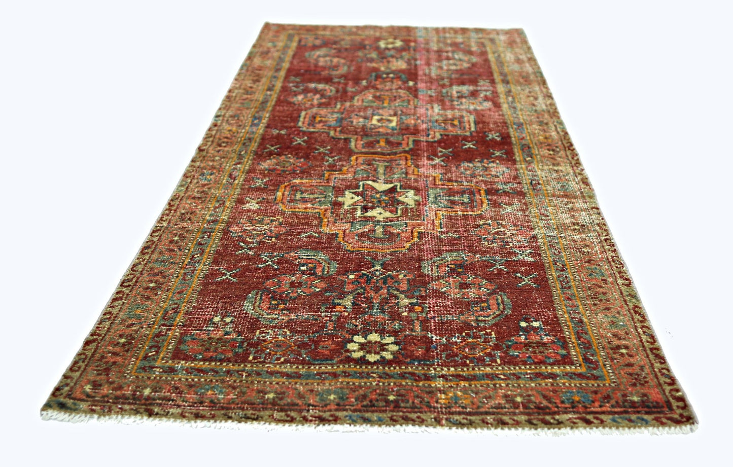 A rectangular vintage Persian rug with a red field and intricate geometric patterns.