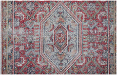 A vintage handwoven Persian rug featuring a central diamond medallion in red, blue, and cream.