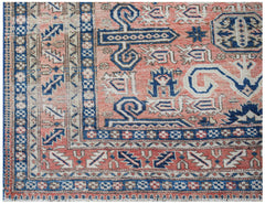 A vintage handwoven Persian rug featuring a geometric pattern in shades of red, blue, and cream.