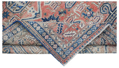 A handwoven vintage Persian rug featuring a geometric pattern in shades of red, blue, and beige.