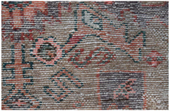 A close-up view of a handwoven vintage Persian rug featuring faded geometric and floral patterns.