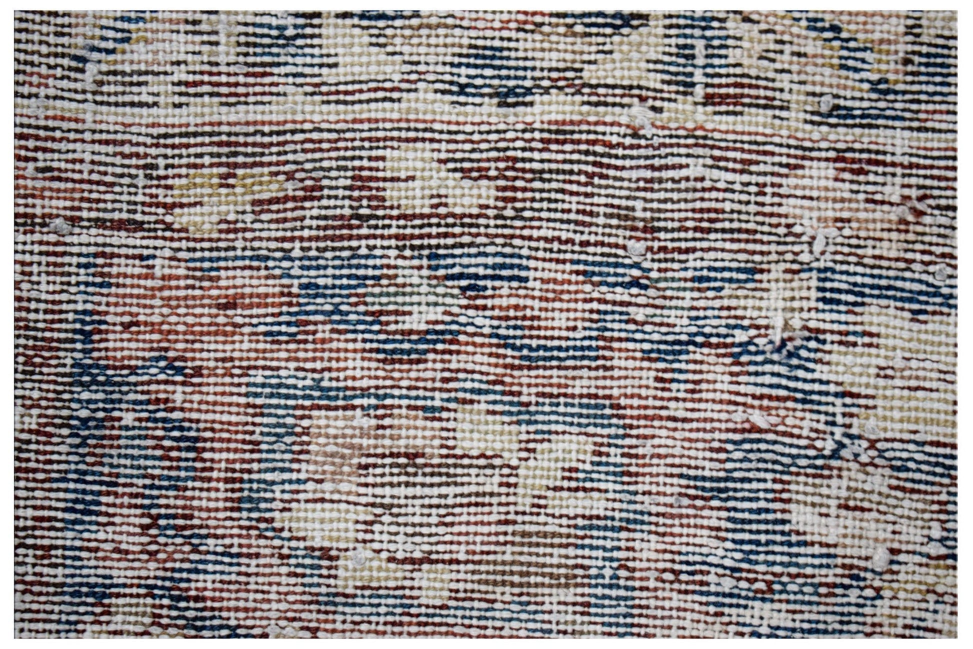A close-up view of a handwoven vintage Persian rug featuring a worn, multicolored wool pattern.