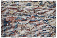 A close-up view of a handwoven vintage Persian rug featuring a worn, multicolored wool pattern.