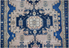 A handwoven vintage Persian wool rug featuring a geometric blue and beige medallion pattern.