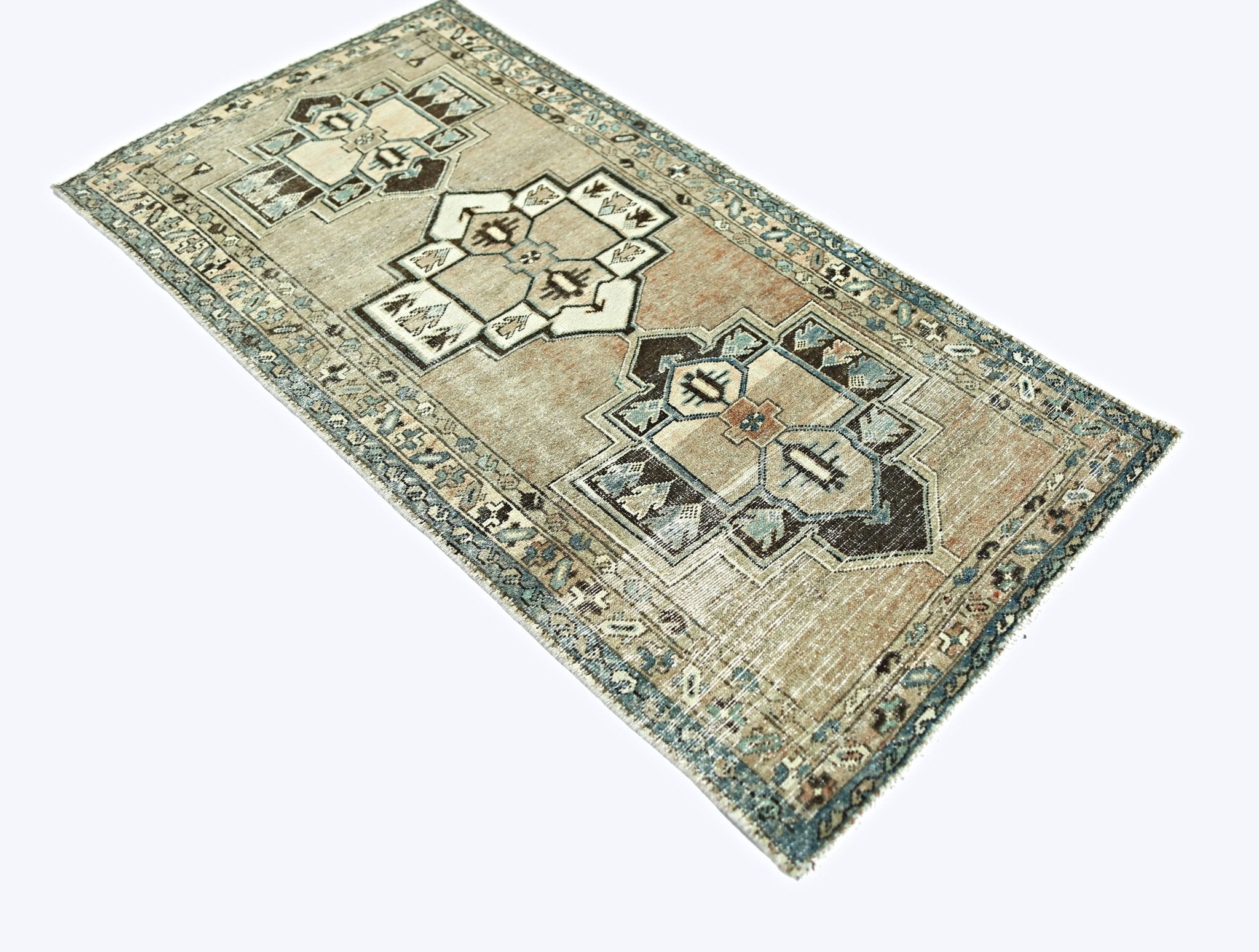A rectangular vintage Persian rug featuring geometric patterns in muted brown and blue tones.