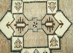 A vintage Persian rug featuring a geometric pattern in shades of beige, brown, and blue.
