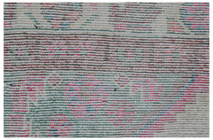 A close-up of a vintage Persian rug featuring a faded, multi-colored striped pattern.