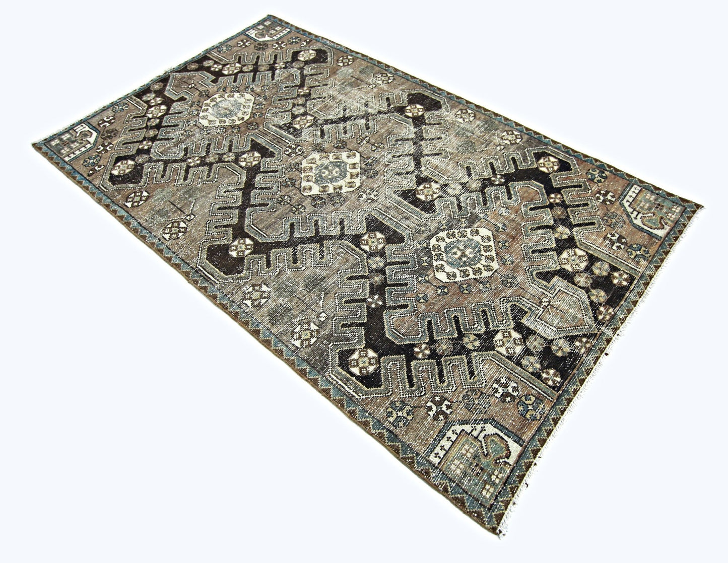 A vintage handmade Persian rug featuring intricate geometric patterns in shades of brown and grey.
