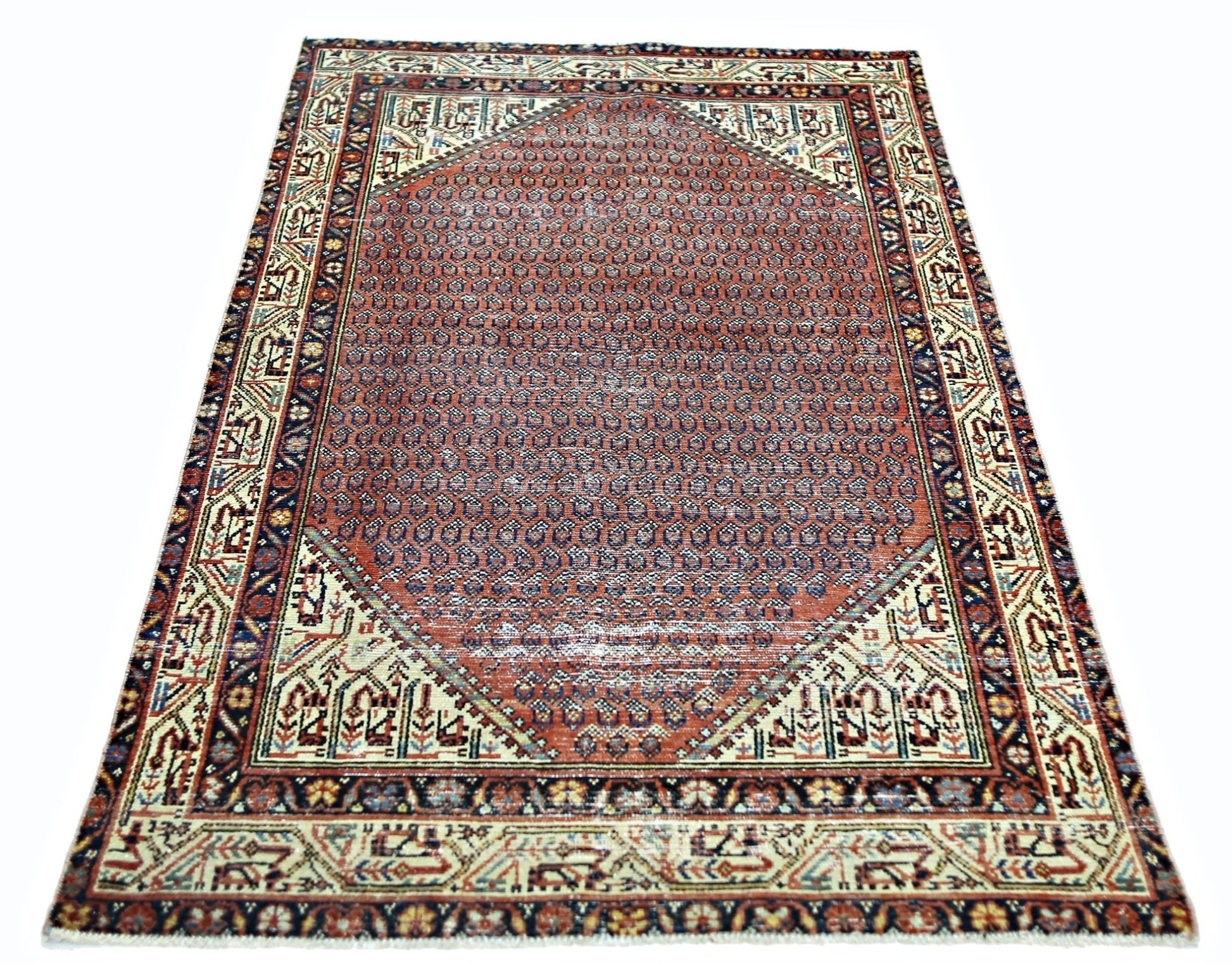 A vintage Persian rug featuring a central hexagonal medallion with a repeating geometric pattern.