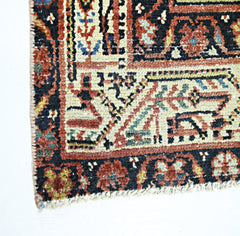A corner view of a vintage handmade Persian rug featuring intricate geometric patterns in wool.