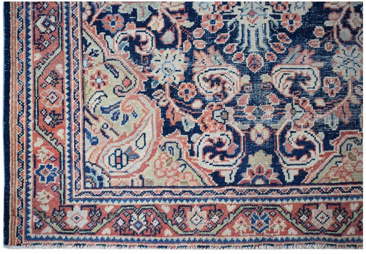 A vintage handwoven Persian rug featuring intricate floral patterns in blue, red, and cream.