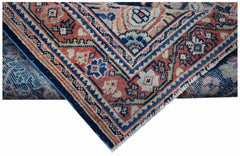 A vintage handwoven Persian rug featuring intricate geometric patterns in red, blue, and cream.