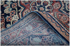 A vintage handwoven Persian rug featuring a traditional floral pattern in red, blue, and cream.