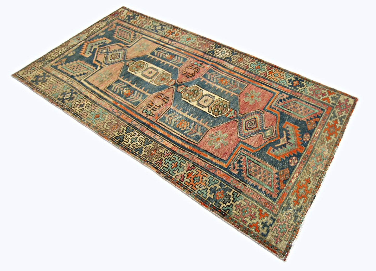A rectangular vintage Persian rug featuring a geometric pattern in shades of blue, red, and tan.