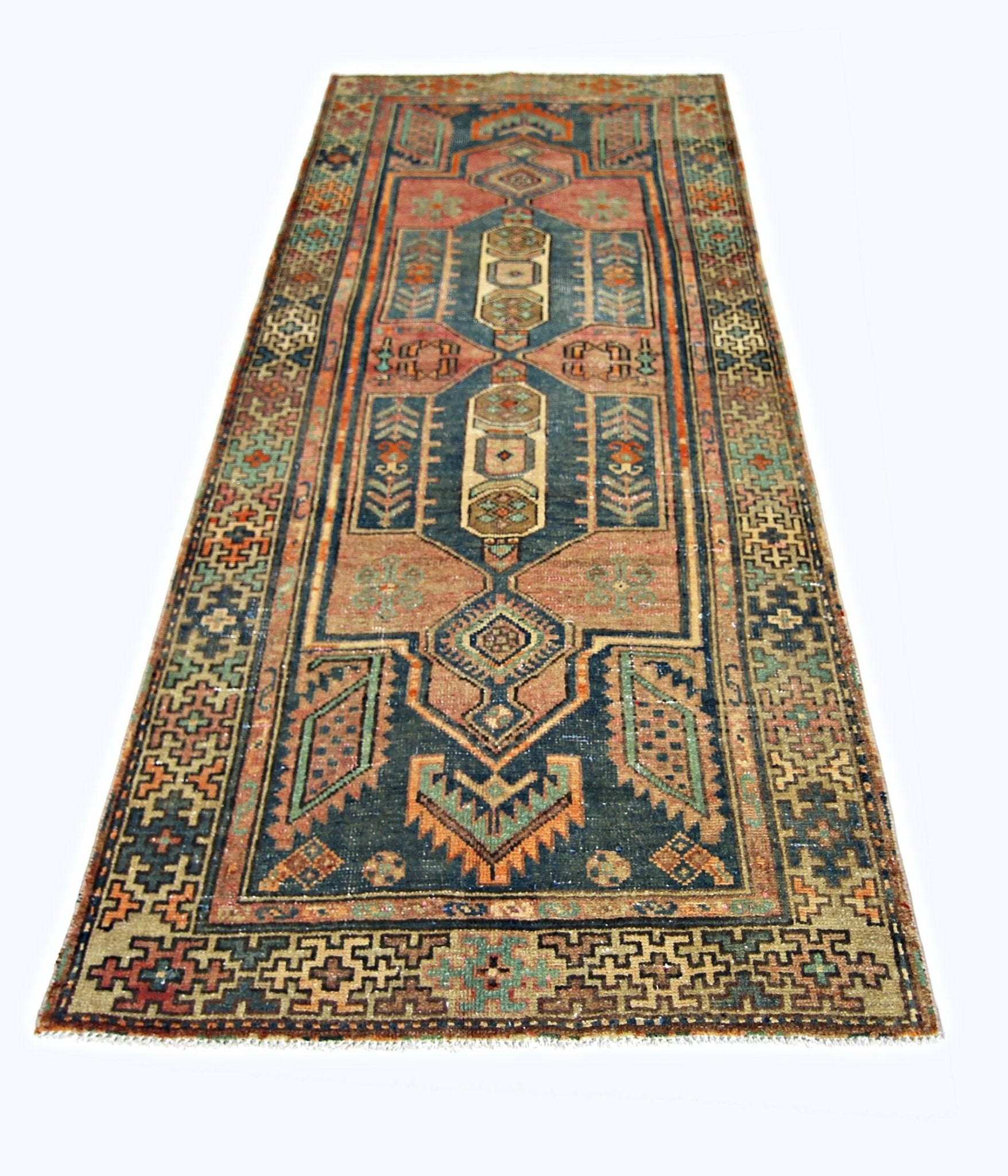 A handmade vintage Persian runner rug featuring geometric patterns in blue, red, and green tones.