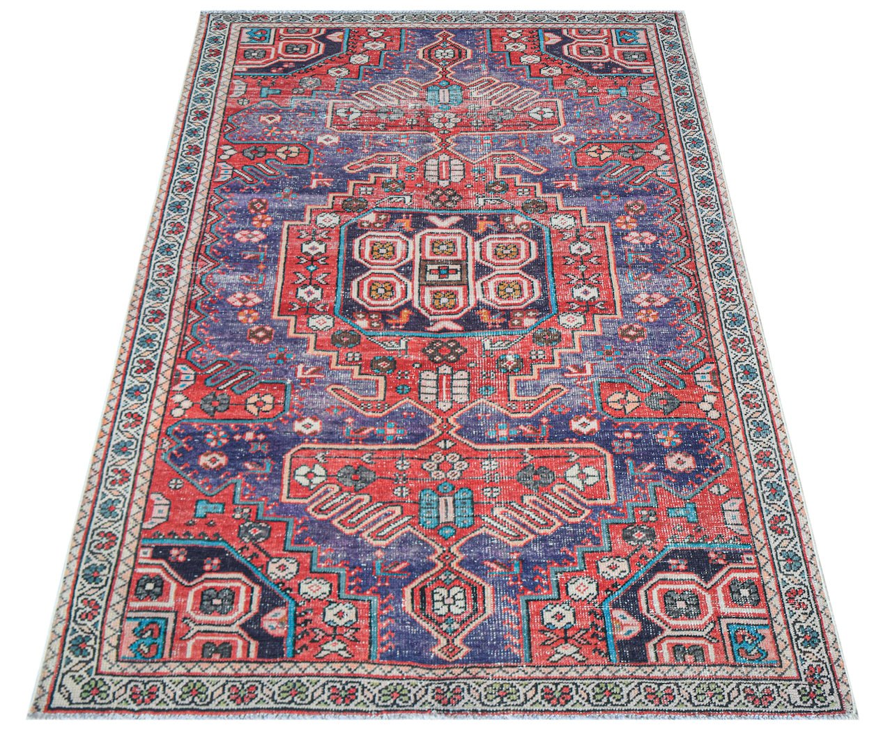 A handwoven vintage Persian rug featuring a geometric pattern in shades of red and blue.
