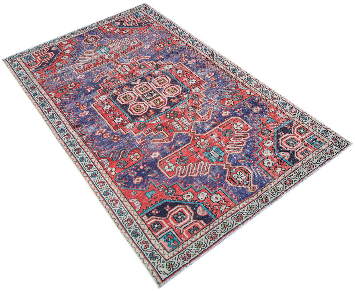A handwoven vintage Persian rug featuring a geometric pattern in shades of red and blue.
