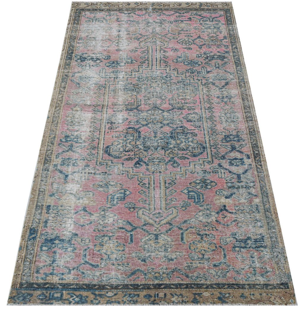 Vintage Persian rug with pink and blue distressed pattern.
